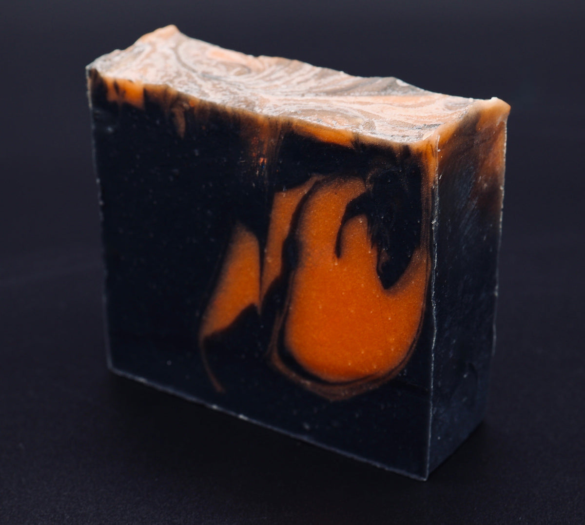 Tick-O-Treat soap side profile showing deep black and vivid orange marbled layers